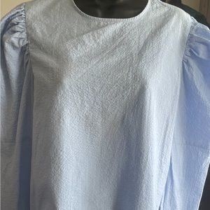 Light blue pucker sleeve long sleeve shirt. Button in the back for closure.